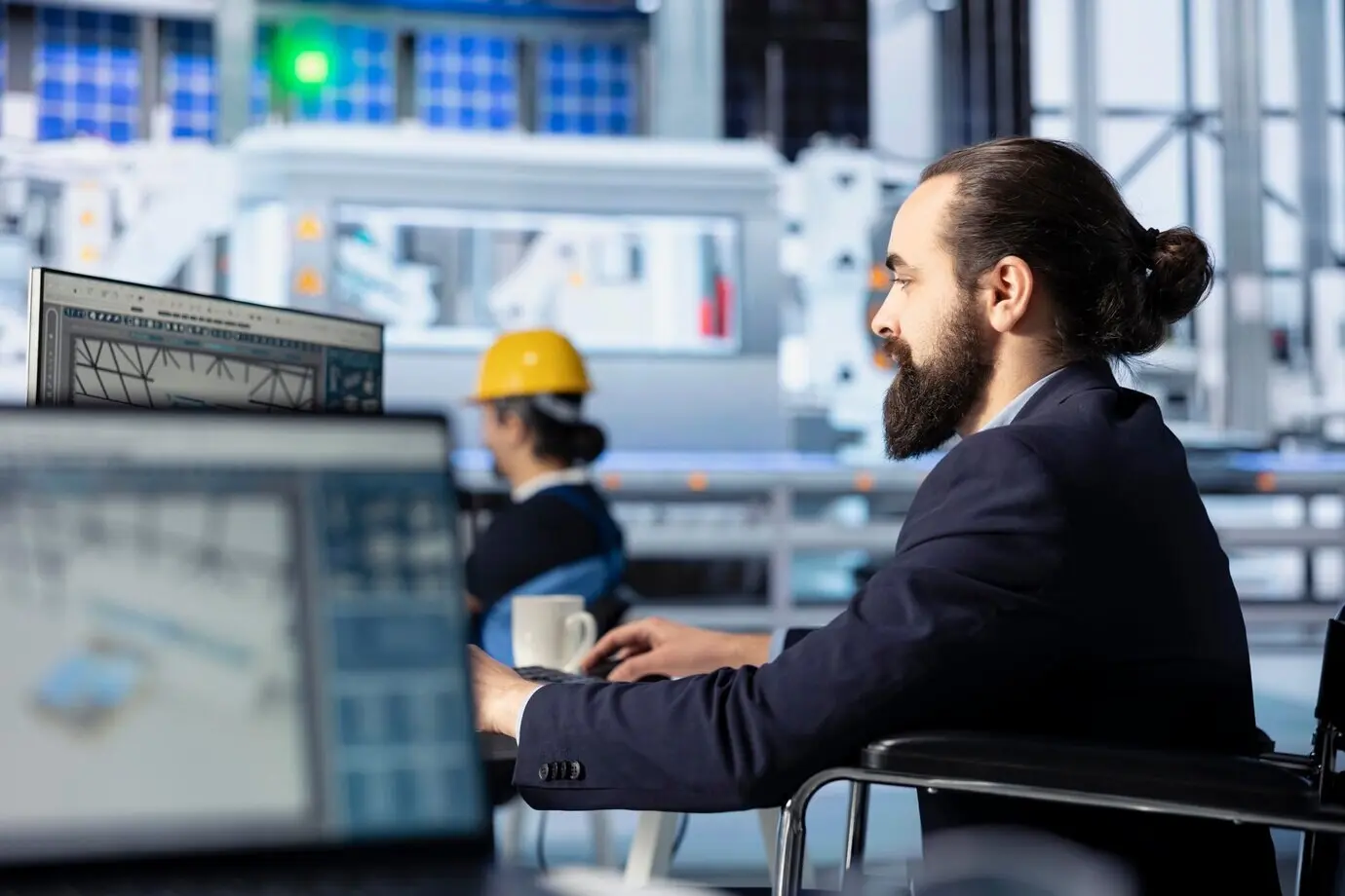 Ingenieur in einer Photovoltaikfabrik schaut auf den PC-Bildschirm und passt Systemparameter an.